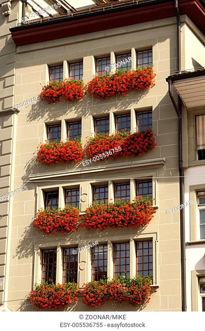 Apartment house with red Geraniums in flower boxes