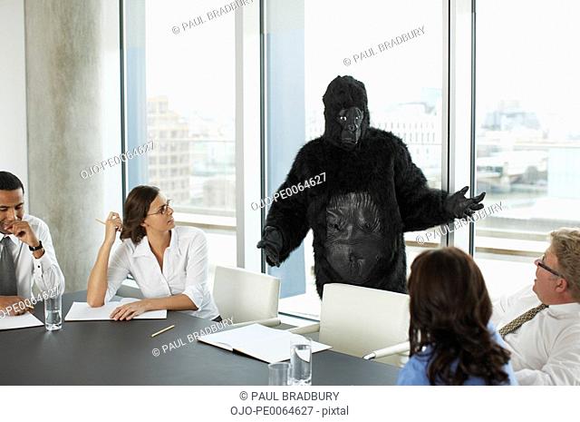 Gorilla and businesspeople having meeting in conference room