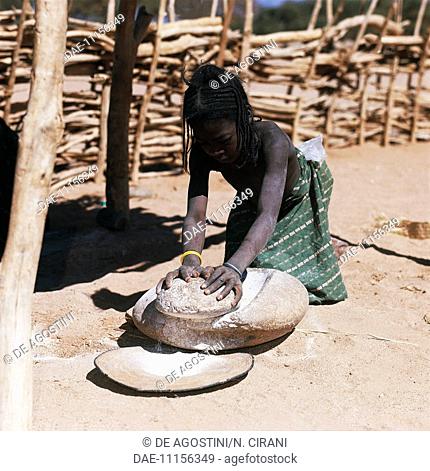 Tuareg girl grinding millet, Iferouane oasis, Air mountains, Agadez region, Niger