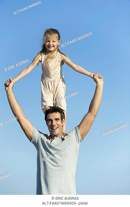 Girl standing on father's shoulders