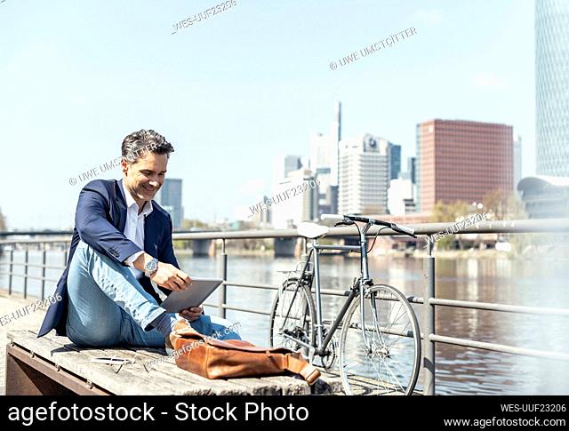 Mature businessman using digital tablet on sunny day
