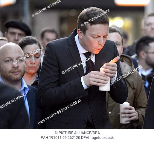 11 October 2019, Saarland, Saarbrücken: Tobias Hans (CDU, Prime Minister of Saarland) blows out a candle shortly before the end of the funeral procession of the...