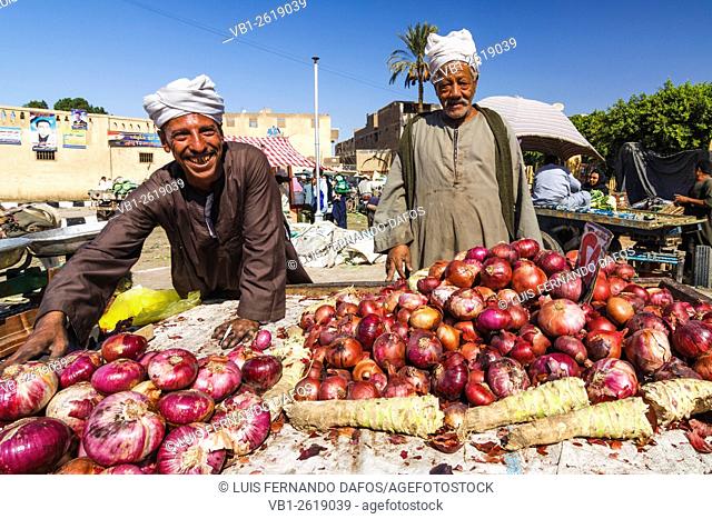 Smiley salesmen selling onions at a stall market in rural Egypt