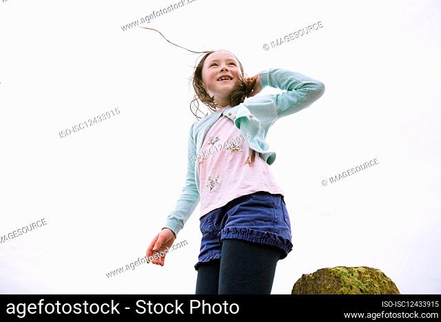 Low angle view of smiling girl (4-5) against sky