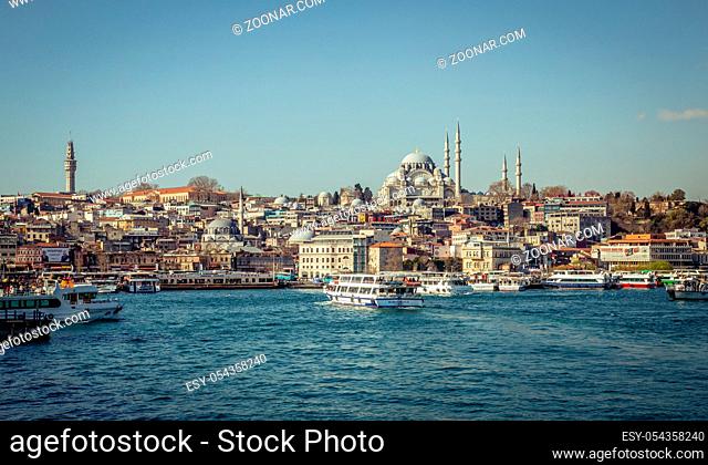 Istanbul, Turkey, 22 March 2019: View to Eminonu pier and Suleymaniye mosque across Bay of Golden Horn on sunny morning. Touristic sightseeing ships in Golden...