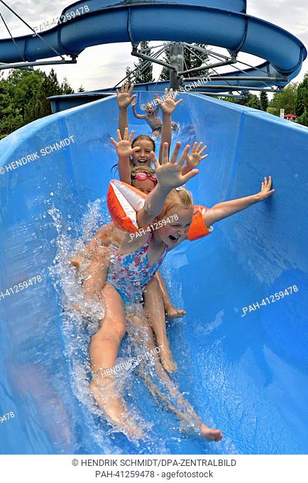 Children slide down the 75 m long waterslide in the bath of Rebesgruen, Germany, 24 July 2013. This weekend the 17th German water sliding championship will take...