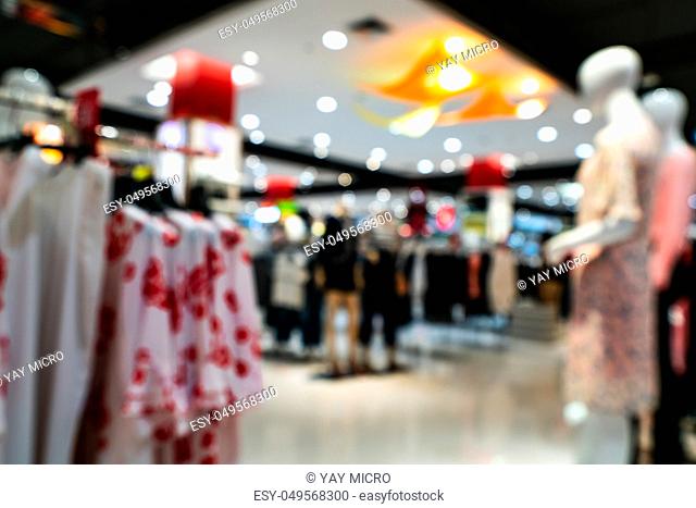 Shopping mall interior blurred background with bokeh. Abstract defocused of women department store in shopping mall. Woman clothing shop