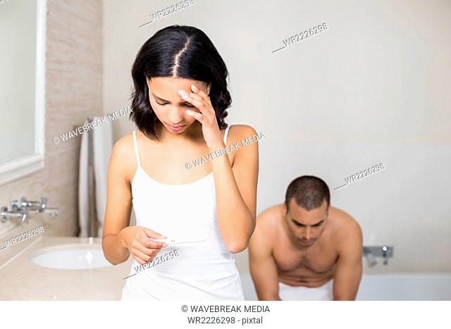 Frustrated couple having a positive pregnancy test