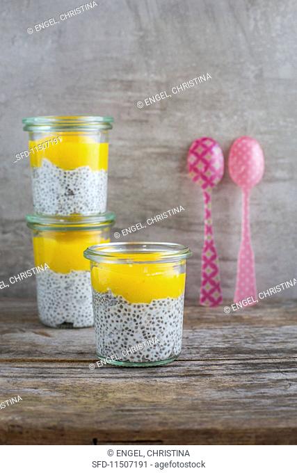 Three glasses of chia and coconut pudding with mango mousse