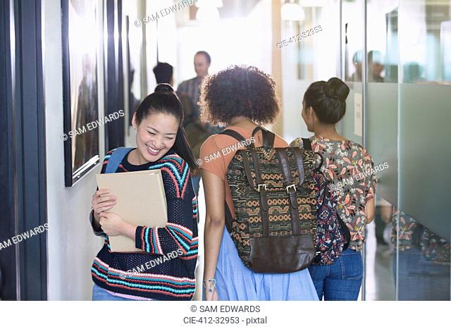 Smiling female college student walking in corridor
