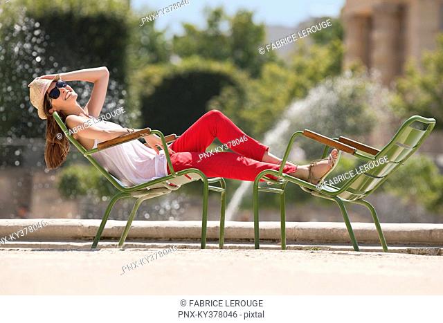 Woman resting in a chair near a pond, Bassin octogonal, Jardin des Tuileries, Paris, Ile-de-France, France