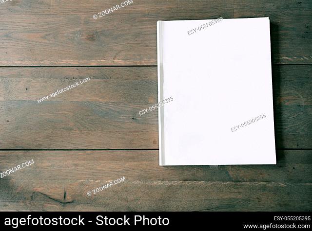 Blank magazine or brochure on wooden background texture, top view and space for text emplate for your design. close-up