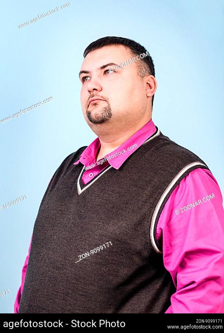 Thoughtful plump businessman on the blue background
