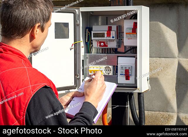 An electrician takes control readings of electricity meters