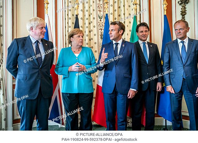 24 August 2019, France (France), Biarritz: German Chancellor Angela Merkel (CDU) stands between Boris Johnson (l), Prime Minister of Great Britain