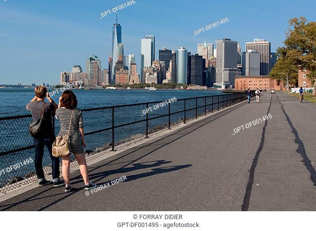 TOURISTS AND NEW YORKERS ADMIRING THE VIEW OF THE MANHATTAN SKYLINE AND THE BAY OF NEW YORK FROM THE PROMENADE ON GOVERNORS ISLAND, THE HILLS, GOVERNORS ISLAND