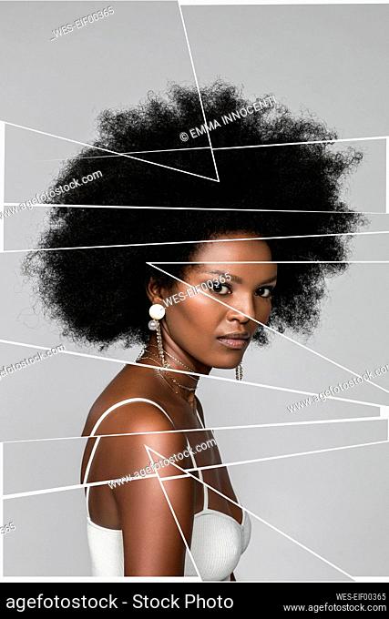Confident Afro woman with digital stripes on face against white background
