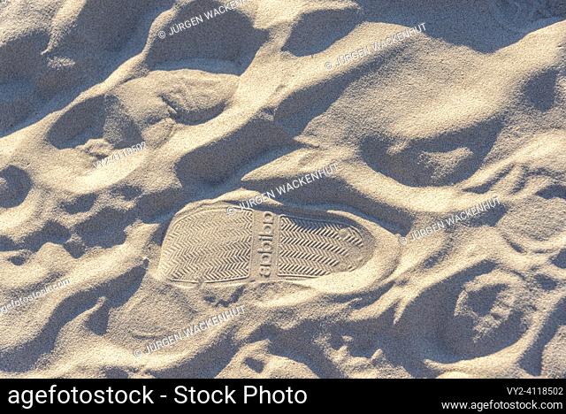 Footprints in the sand with the Adidas brand logo