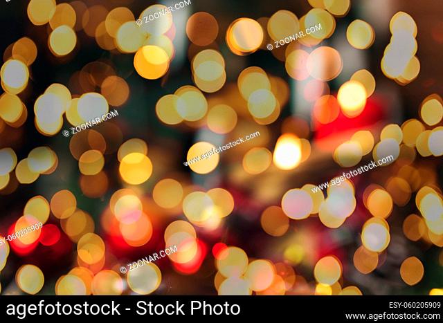 Red christmas decorations on the table at blurred christmas tree with candles . High quality photo