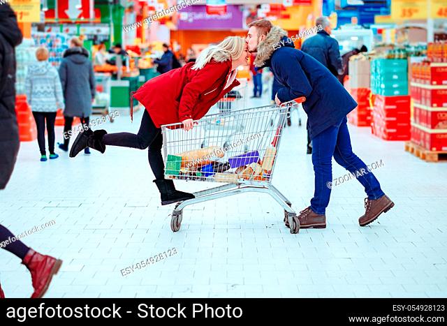 Image of young smilling women and boy friends. Have fun with shopping trolley