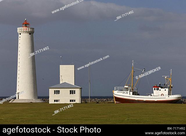 Lighthouse Garðskagaviti, next to it maritime museum and old fishing boat, Garður, Suðurnes, Reykjanes Peninsula, Iceland, Europe