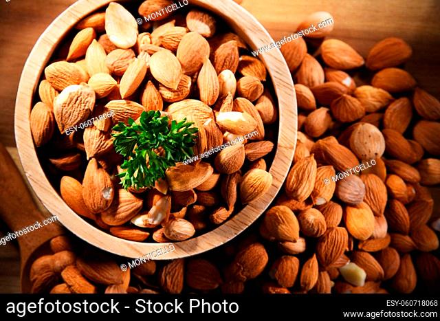 Bowl of apricot kernels on wooden table