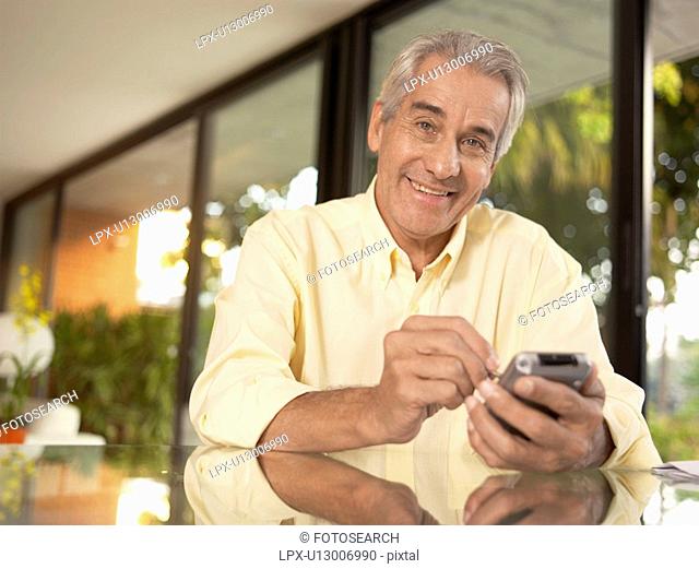 Mature man using PDA portrait