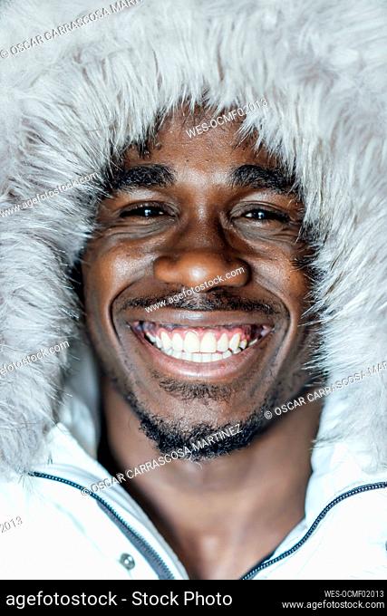 Smiling young man in white fur hat