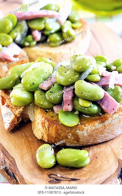Bruschetta fave e prosciutto toasted bread topped with broad beans