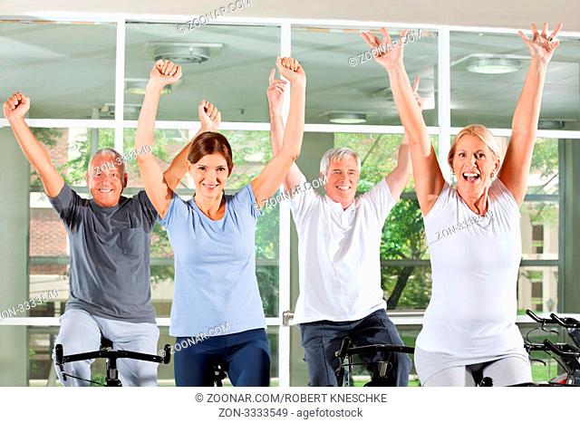 Jubelnde Senioren im Fitnesscenter ballen ihre Fäuse