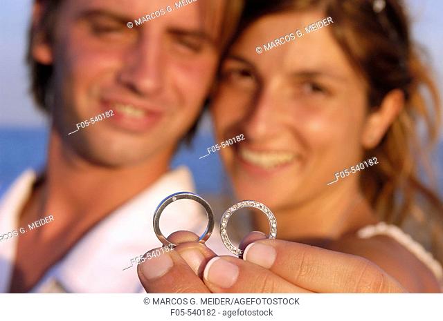 Newly young married couple showing their wedding rings
