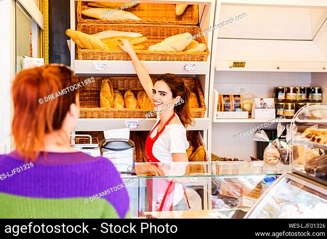 Young woman serving female customer in a bakery