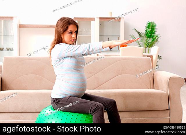 Young pregnant woman doing sport exercises at home