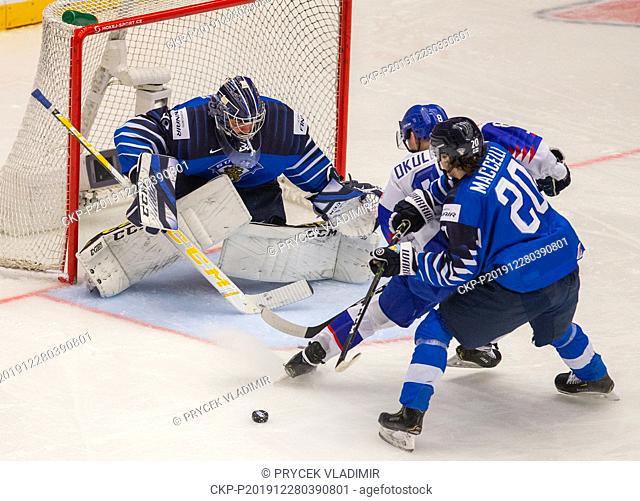 Finland's Matias Maccelli, right, and Slovakia's Oliver Okuliar, centre, vie for the puck in front of Finland's goaltender Justus Annunen during the 2020 IIHF...