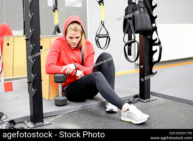 erschöpfte Frau im Fitnessstudio  exhausted young woman sitting in gym