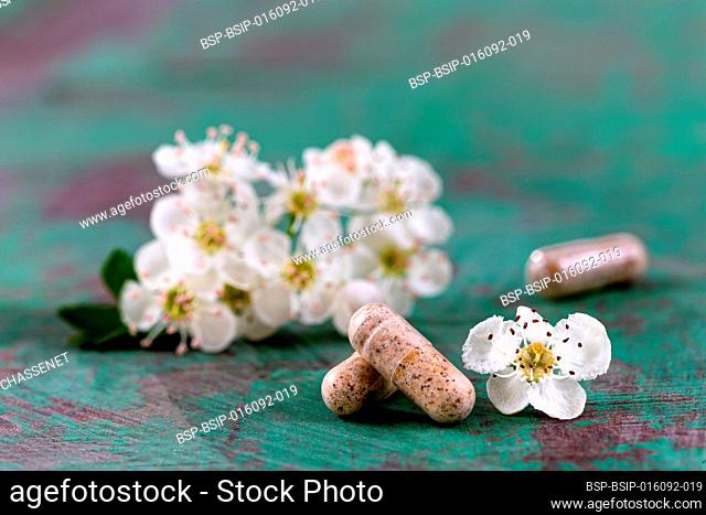 Capsule of food supplements and white flowers