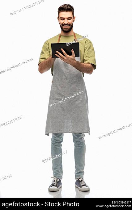 smiling waiter in apron with tablet pc computer