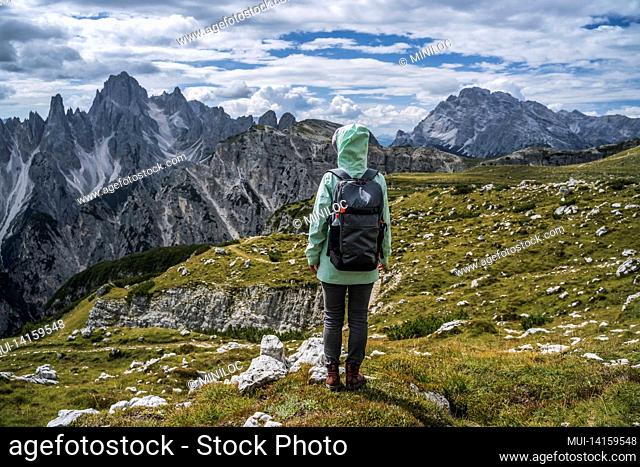 woman hiker with backpack against cadini di misurina mountain group range of italian alps, dolomites, italy, europe