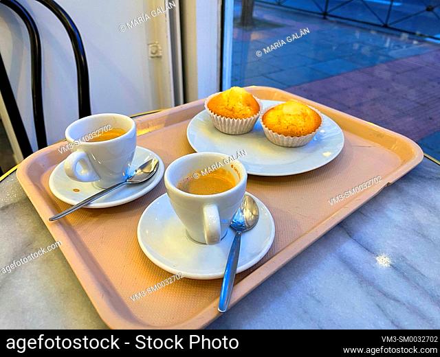 Two cups of coffee with two muffins in a cafeteria