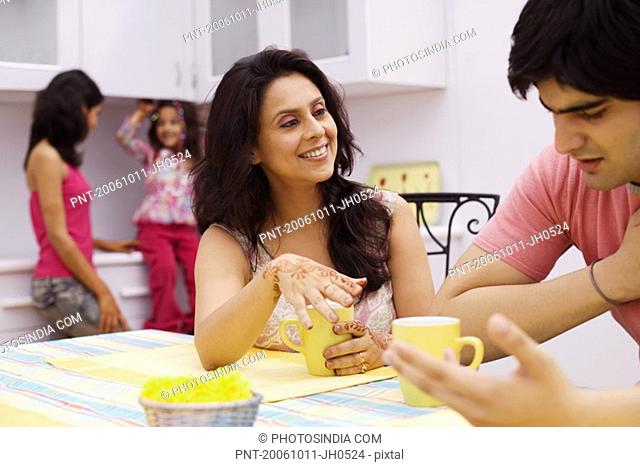 Young man and a mid adult woman sitting at a dining table