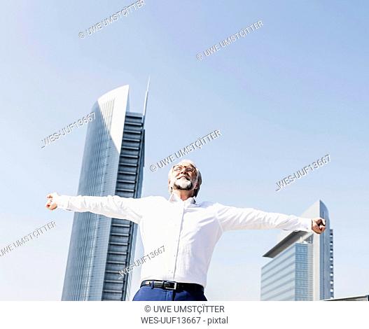 Happy mature businessman cheering in the city