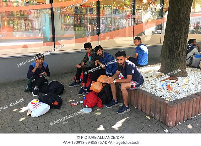 10 September 2019, Bosnia and Herzegovina, Bihac: Migrants sit in front of a shop in the centre of the city. The small town of Bihac on the border with Croatia...