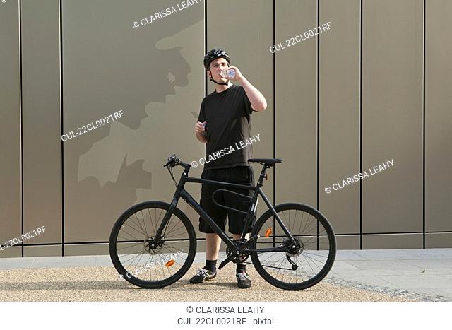 Man with bicycle drinking water