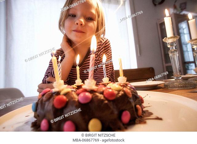Small girl in front of birthday cake