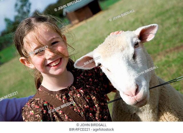 Young girl stroking a sheep on a visit to a city farm