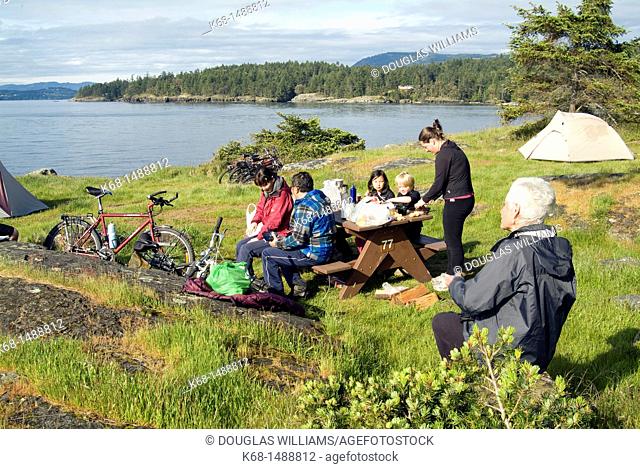 a group of campers relaxes at Ruckle Park campground on Saltspring Island, Gulf Islands, BC, Canada