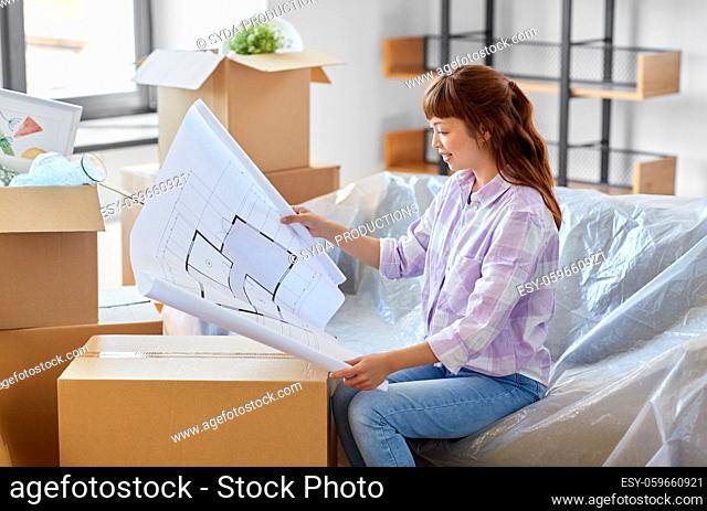 woman with blueprint and boxes moving to new home