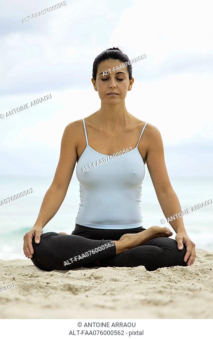 Mature woman meditating on beach, portrait