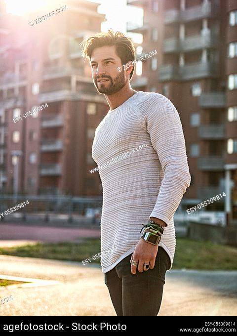 One handsome young man in urban setting in European city, standing