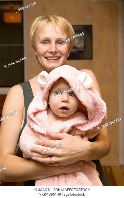 Young Happy Caucasian Woman Holding Baby Girl in Bathrobe
